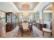 Formal dining room with chandelier, decorative ceiling, and large windows dressed in elegant drapery at 6515 Eagle View Loop, Lakeland, FL 33813