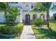 Inviting front entrance featuring arched doorways, stone accents, and lush greenery, creating a welcoming ambiance at 6515 Eagle View Loop, Lakeland, FL 33813