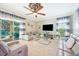 Sunlit living room with tile flooring, a ceiling fan, and view to pool at 6515 Eagle View Loop, Lakeland, FL 33813