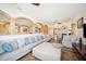 Living room area with neutral color sofa, arches, built ins, tile flooring, and ceiling fans at 6515 Eagle View Loop, Lakeland, FL 33813