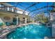 Inviting screened-in pool area with outdoor kitchen, seating, and a tranquil waterfall feature at 6515 Eagle View Loop, Lakeland, FL 33813