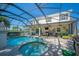 Backyard pool and hot tub with screened enclosure, covered patio, and lush landscaping at 6515 Eagle View Loop, Lakeland, FL 33813