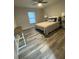 Well-lit bedroom featuring a ceiling fan, wood-look floors, and natural light through a window at 692 Augusta Rd, Winter Haven, FL 33884