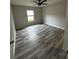 A bright bedroom with a neutral color palette, large window and wood-look flooring at 692 Augusta Rd, Winter Haven, FL 33884