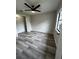 Bedroom features gray flooring, a ceiling fan, and a window at 692 Augusta Rd, Winter Haven, FL 33884