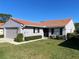 Charming single-story home featuring a well-maintained lawn and a red tile roof on a clear day at 692 Augusta Rd, Winter Haven, FL 33884