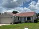 Charming single-story home featuring a red tile roof, neutral stucco, well-maintained lawn, and attached two-car garage at 692 Augusta Rd, Winter Haven, FL 33884