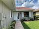 Inviting front entryway with a white door, neutral exterior, manicured landscaping, and a stone walkway at 692 Augusta Rd, Winter Haven, FL 33884