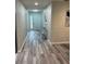 Inviting hallway featuring light gray walls, modern decor, and attractive wood-look floors at 692 Augusta Rd, Winter Haven, FL 33884