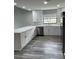 Kitchen features stainless steel appliances, gray wood flooring, and white cabinets at 692 Augusta Rd, Winter Haven, FL 33884