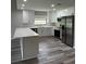 Kitchen features modern appliances, quartz countertops, subway tile backsplash, and gray wood floors at 692 Augusta Rd, Winter Haven, FL 33884