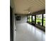 Relaxing lanai featuring tiled floor, ceiling fan, and windows overlooking the lush outdoors at 692 Augusta Rd, Winter Haven, FL 33884