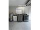 Functional laundry area with modern washer, dryer, sink, and water heater at 692 Augusta Rd, Winter Haven, FL 33884