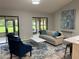 Bright living room featuring vaulted ceilings, a stylish blue rug, modern furniture, and sliding glass doors at 692 Augusta Rd, Winter Haven, FL 33884