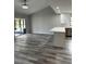 Bright living room with updated flooring, modern lighting, and access to the screened patio at 692 Augusta Rd, Winter Haven, FL 33884