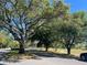 Picturesque street view with mature trees and landscaping showcasing the beautiful community at 692 Augusta Rd, Winter Haven, FL 33884