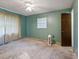 Bare bedroom with a ceiling fan, window, and blue-green painted walls ready for personalization and creative design at 6940 Newman E Cir, Lakeland, FL 33811