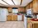 Functional kitchen featuring wood cabinets, tile floors, and natural light from the ceiling window at 6940 Newman E Cir, Lakeland, FL 33811