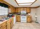 Functional kitchen featuring wood cabinets, tile floors, and natural light from the ceiling window at 6940 Newman E Cir, Lakeland, FL 33811