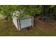 Exterior of a garage/outbuilding featuring a roll-up door in a grassy backyard at 6940 Newman E Cir, Lakeland, FL 33811