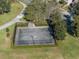 Aerial view of community basketball court surrounded by green lawns and lush trees at 726 Chacall Loop, Mount Dora, FL 32757