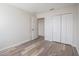 Bright bedroom featuring wood-look flooring, closet, and neutral walls at 726 Chacall Loop, Mount Dora, FL 32757