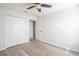 Clean bedroom with wood floors, a closet and modern ceiling fan with light at 726 Chacall Loop, Mount Dora, FL 32757