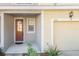 Inviting front entrance with a charming door, covered porch, and a one car garage on a yellow home at 726 Chacall Loop, Mount Dora, FL 32757