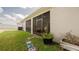 View of the back of the house with a screened-in patio and well-maintained lawn at 7289 Liberty Rd, Lakeland, FL 33809