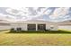 Wide view of the backyard showcasing the lawn, back of the house, and screened patio at 7289 Liberty Rd, Lakeland, FL 33809