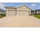 View of the two-car garage featuring neutral paint color and stone detailing on the front exterior at 7289 Liberty Rd, Lakeland, FL 33809