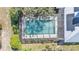 Aerial view of a screened pool surrounded by lush landscaping, solar panels, and metal roof at 8621 Plantation Ridge Blvd, Lakeland, FL 33809