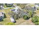 Aerial view showcasing metal roof, solar panels, screened pool, and surrounded by mature trees at 8621 Plantation Ridge Blvd, Lakeland, FL 33809