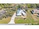 Aerial view of a home with metal roof, landscaped front, long driveway, and mature trees at 8621 Plantation Ridge Blvd, Lakeland, FL 33809