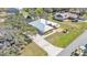 Aerial view of a home with metal roof, well-manicured lawn, long driveway, and mature trees at 8621 Plantation Ridge Blvd, Lakeland, FL 33809