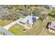 Aerial view of a home with a metal roof, solar panels, long driveway and many trees at 8621 Plantation Ridge Blvd, Lakeland, FL 33809