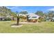 Beautiful house with a distinctive metal roof, stone details, and a mature palm tree in the yard at 8621 Plantation Ridge Blvd, Lakeland, FL 33809