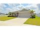 Inviting single-story home with a two-car garage, lush landscaping, and a well-maintained front lawn at 937 Montgomery Ln, Polk City, FL 33868