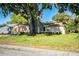 Charming single-story home featuring a manicured lawn and mature trees in a suburban setting at 1225 Pleasant Pl, Lakeland, FL 33801