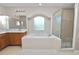 Bright bathroom with a soaking tub, a separate shower, and dual sinks beneath a large mirror at 124 Brandy Chase Blvd, Winter Haven, FL 33880