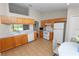 Spacious kitchen with oak cabinets, white appliances, and a tile backsplash at 124 Brandy Chase Blvd, Winter Haven, FL 33880