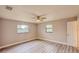 This bedroom features wood-look floors, a ceiling fan, two windows and fresh neutral paint at 135 Kenilwood Ln, Lakeland, FL 33809