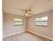 This bedroom features wood-look floors, a ceiling fan, two windows and fresh neutral paint at 135 Kenilwood Ln, Lakeland, FL 33809
