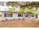 Charming one-story home with a white brick exterior, complemented by dark shutters at 135 Kenilwood Ln, Lakeland, FL 33809