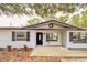 Charming home featuring a brick exterior, black shutters, and a welcoming front porch swing at 135 Kenilwood Ln, Lakeland, FL 33809