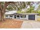 Charming single-story home with a white brick facade, dark trim, and an inviting front porch swing at 135 Kenilwood Ln, Lakeland, FL 33809
