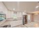 Modern kitchen with white cabinets, stainless steel appliances, and a view of the backyard pool at 135 Kenilwood Ln, Lakeland, FL 33809