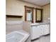 Bathroom with double sinks, white cabinetry, a jacuzzi tub, and mirrors at 14 Casarena Ct, Winter Haven, FL 33881