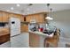 Bright kitchen with wooden cabinets, white appliances, tile countertops, and a casual breakfast bar at 14 Casarena Ct, Winter Haven, FL 33881