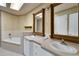 Elegant main bathroom with double sinks, a soaking tub, and decorative mirrors at 14 Casarena Ct, Winter Haven, FL 33881